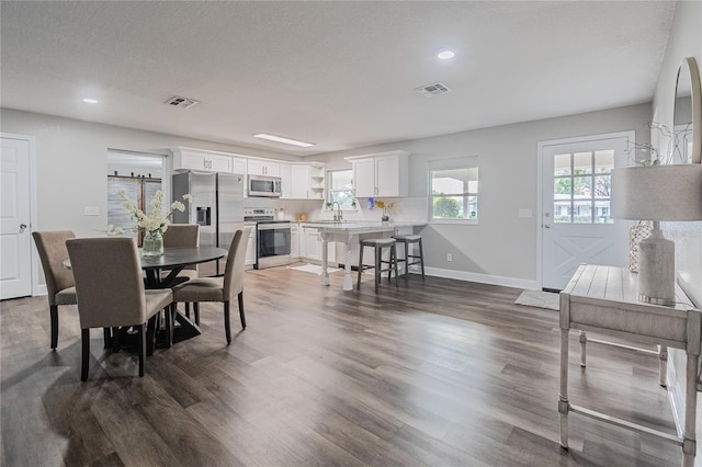 dining room featuring a textured ceiling and dark hardwood / wood-style flooring