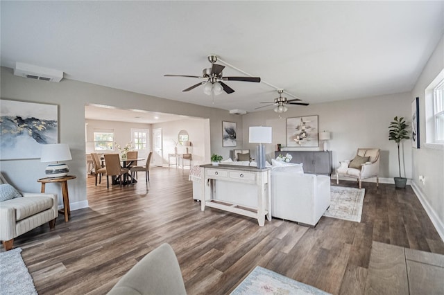 living room with dark wood-type flooring and ceiling fan