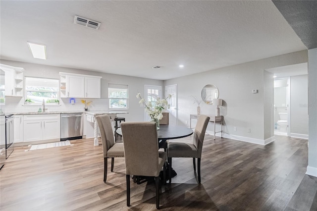 dining space featuring sink and light wood-type flooring