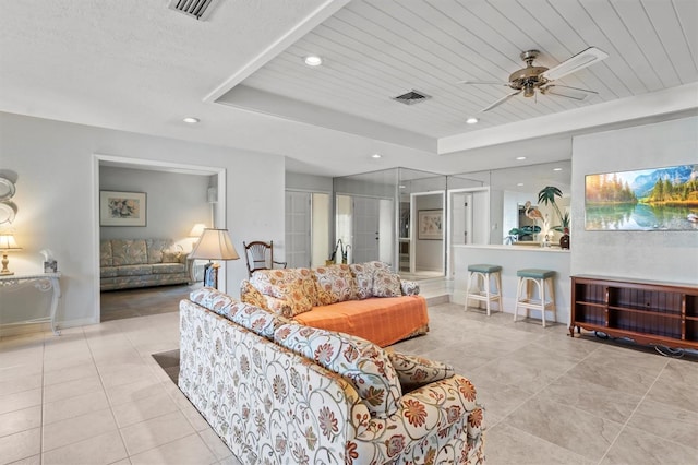 tiled living room featuring a raised ceiling, ceiling fan, french doors, and wood ceiling