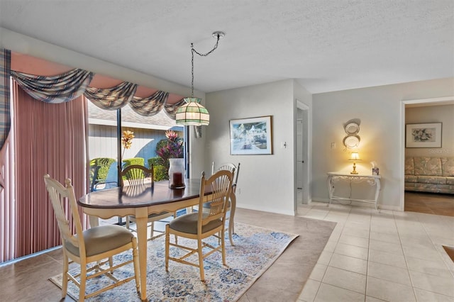 tiled dining area featuring a textured ceiling