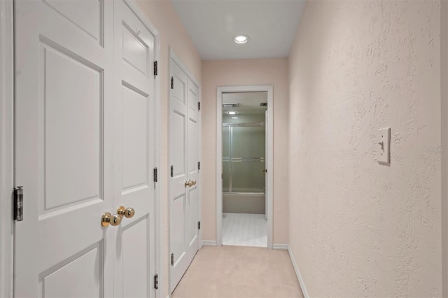 hallway featuring light colored carpet