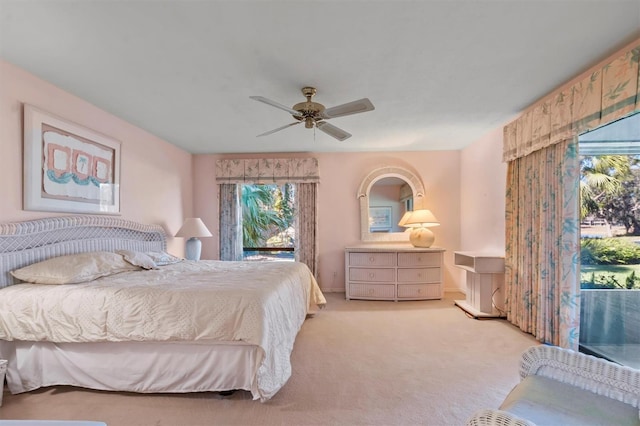 carpeted bedroom featuring ceiling fan and multiple windows