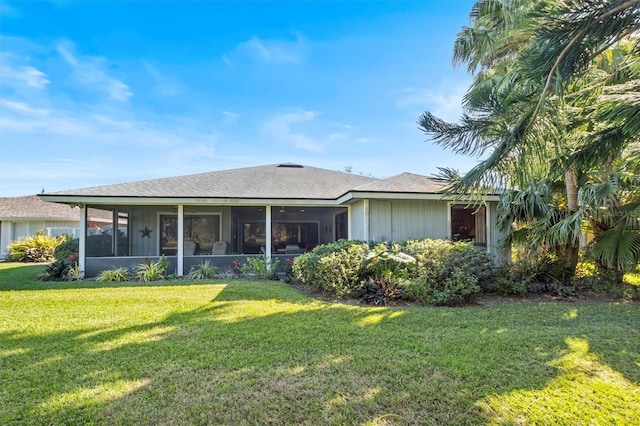 rear view of property with a sunroom and a yard