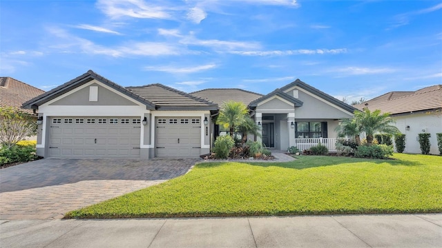 ranch-style home featuring a front yard, a porch, and a garage