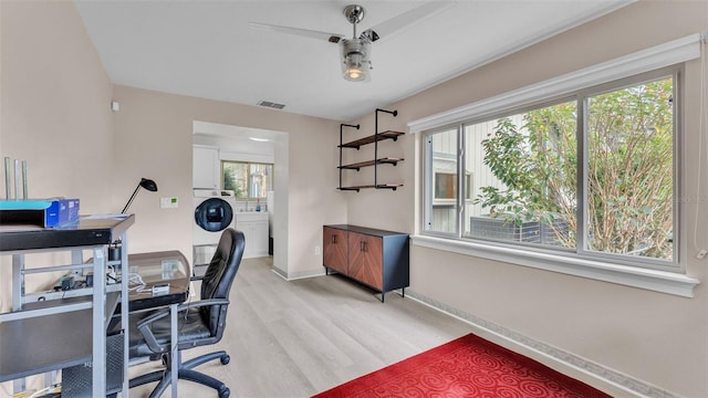 office area with washer / clothes dryer, a wealth of natural light, and light hardwood / wood-style flooring