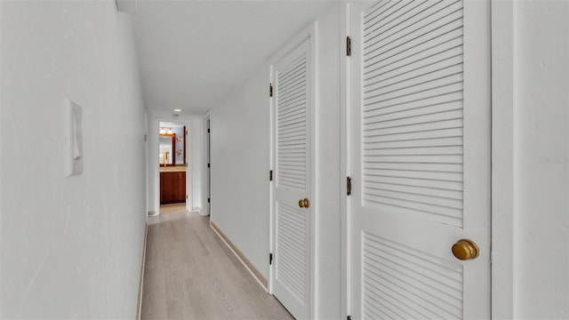 corridor with light hardwood / wood-style floors