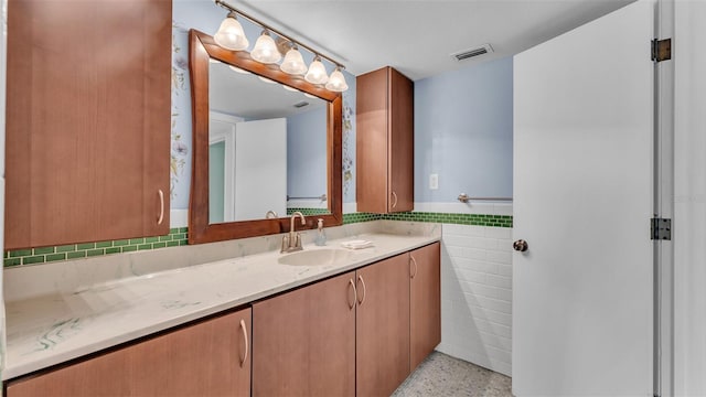 bathroom featuring vanity and tile walls