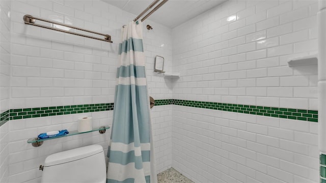 bathroom with toilet, tile walls, and a shower with shower curtain