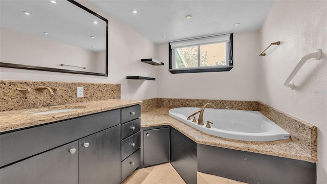 bathroom with tile patterned floors, a bathtub, and vanity