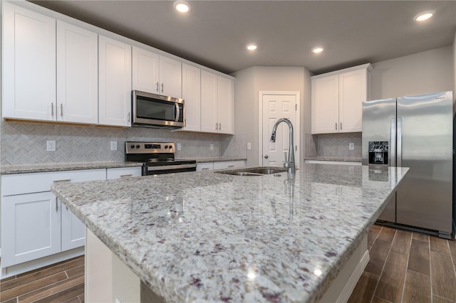 kitchen with sink, an island with sink, and appliances with stainless steel finishes