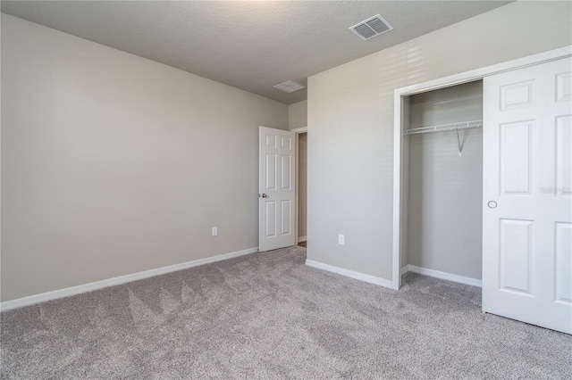 unfurnished bedroom featuring light colored carpet and a closet