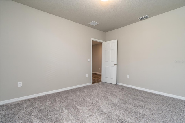 carpeted spare room featuring a textured ceiling