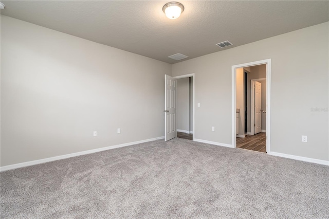 unfurnished bedroom featuring a textured ceiling and carpet floors