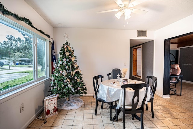 tiled dining space featuring a wealth of natural light and ceiling fan