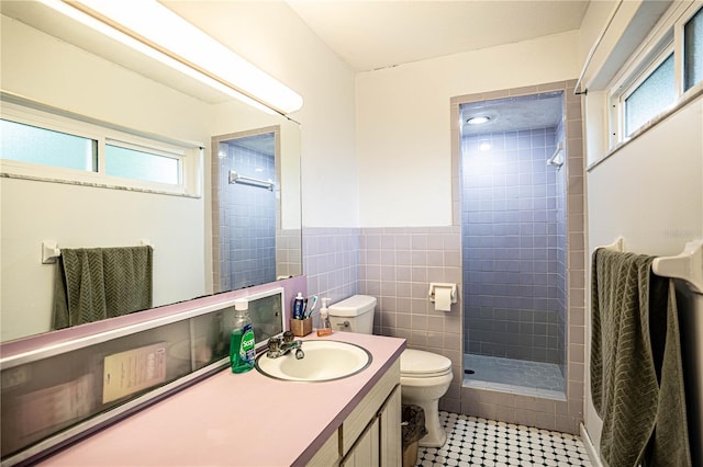 bathroom with tiled shower, toilet, a wealth of natural light, and tile walls