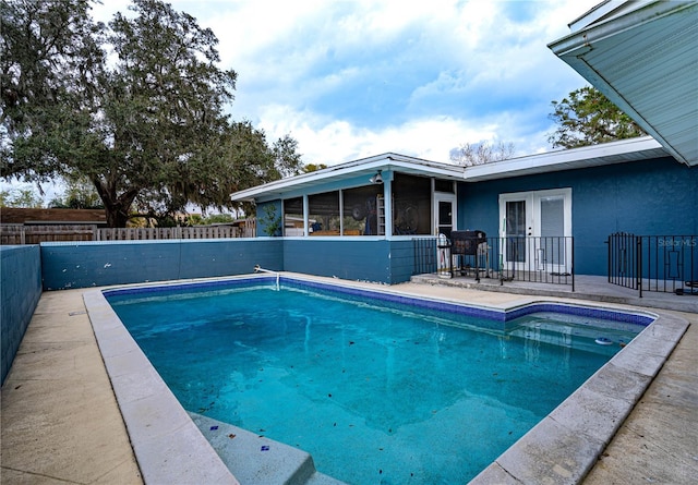 view of swimming pool featuring a patio area and french doors