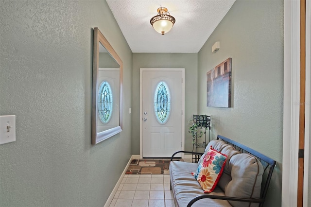 foyer entrance with tile patterned floors, a textured wall, and baseboards