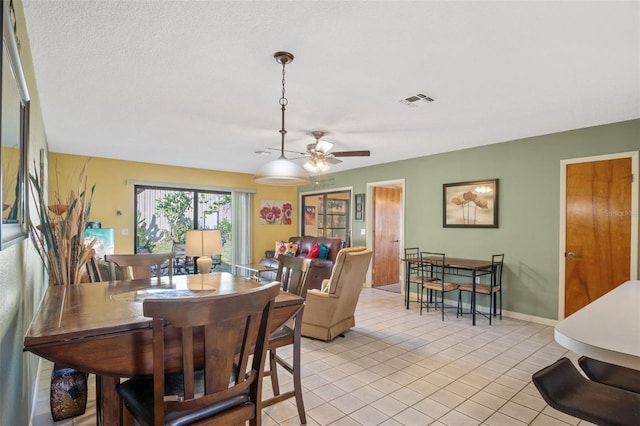 dining room featuring light tile patterned floors, baseboards, ceiling fan, and visible vents