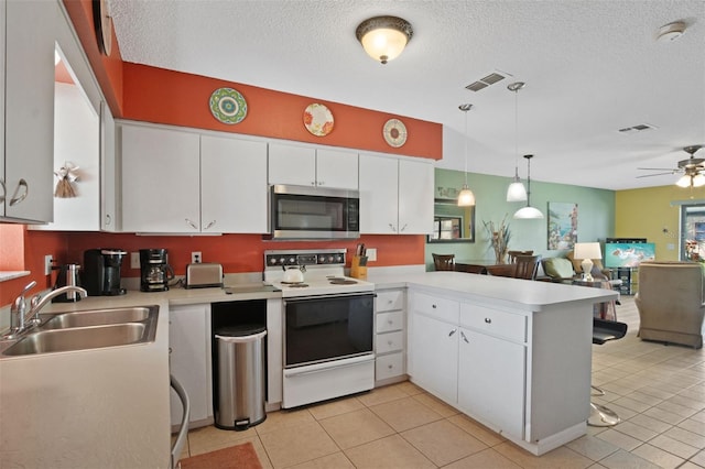 kitchen featuring a sink, white range with electric stovetop, visible vents, and stainless steel microwave