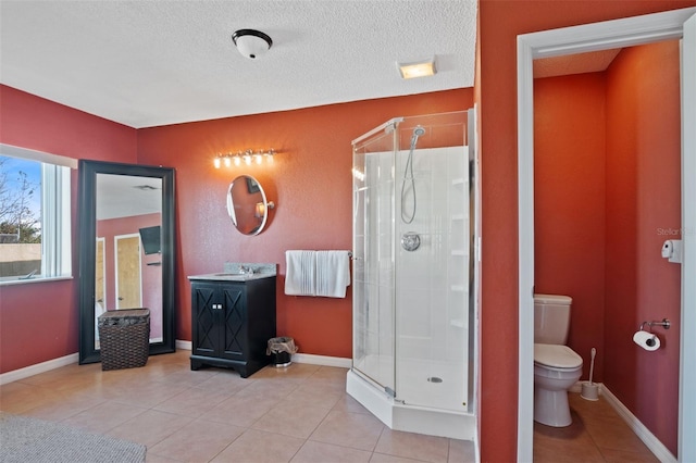full bathroom featuring toilet, a stall shower, baseboards, and tile patterned floors