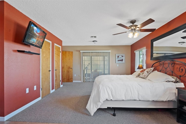 bedroom with carpet, baseboards, a textured ceiling, ceiling fan, and visible vents
