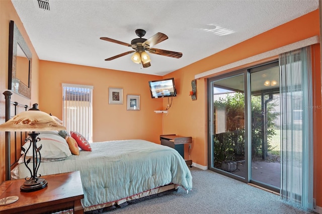 bedroom with a textured ceiling, baseboards, carpet, and access to outside