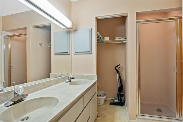 bathroom with double vanity, a sink, toilet, and a shower stall