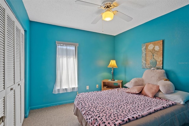 carpeted bedroom with a closet, a textured ceiling, and a ceiling fan