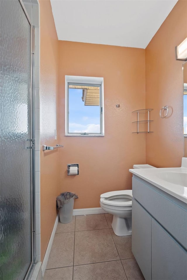 full bathroom with baseboards, toilet, tile patterned floors, vanity, and a stall shower