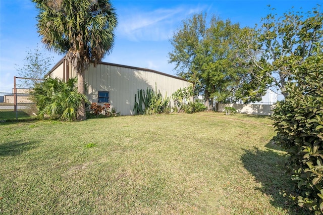 view of yard with an outdoor structure, an outbuilding, and fence