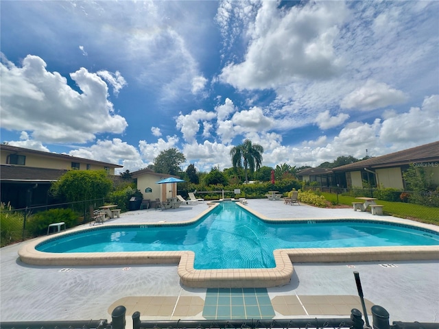community pool featuring fence and a patio