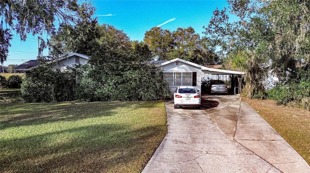 view of front of home with a front yard and a carport