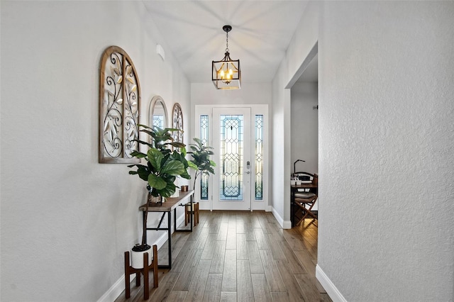 entryway with dark hardwood / wood-style flooring and an inviting chandelier