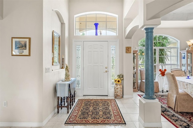 entrance foyer featuring ornate columns, a high ceiling, and light tile patterned floors