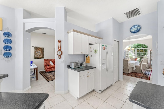 kitchen featuring a notable chandelier, white cabinetry, white fridge with ice dispenser, and light tile patterned floors