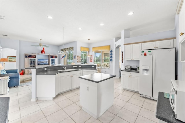 kitchen featuring white appliances, kitchen peninsula, ceiling fan, decorative light fixtures, and white cabinetry