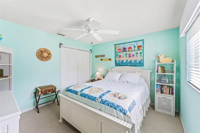 carpeted bedroom with multiple windows, a closet, and ceiling fan