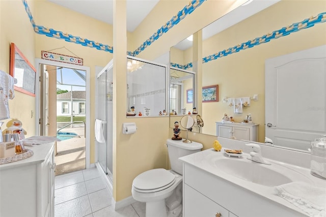 bathroom featuring tile patterned flooring, vanity, a shower with door, and toilet