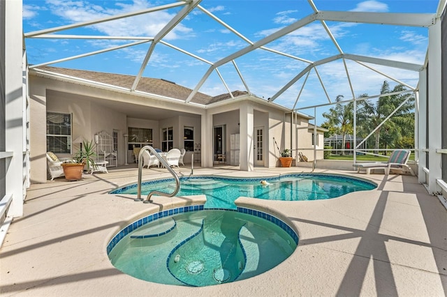 view of pool with a lanai, a patio, and an in ground hot tub