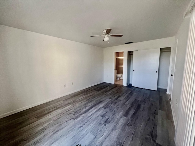 unfurnished bedroom with ceiling fan, dark hardwood / wood-style floors, connected bathroom, and a closet