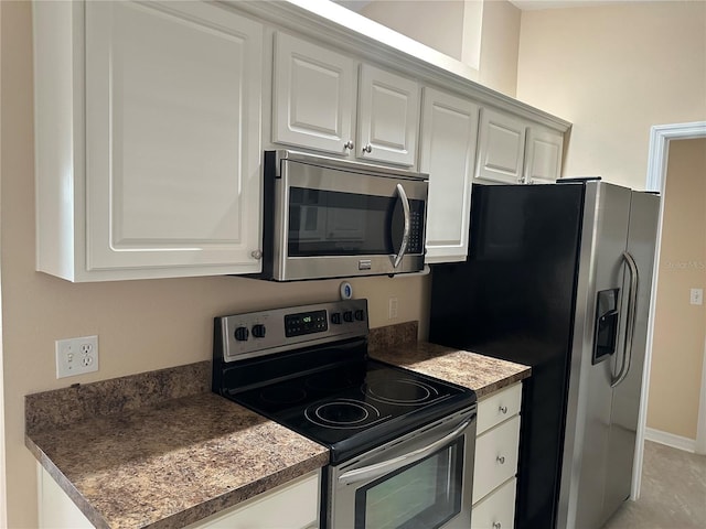 kitchen featuring white cabinets, light tile patterned floors, and stainless steel appliances