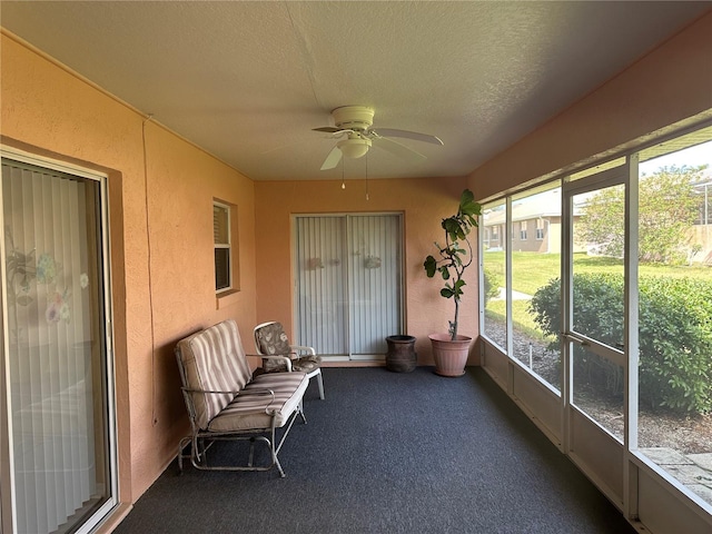 unfurnished sunroom with ceiling fan