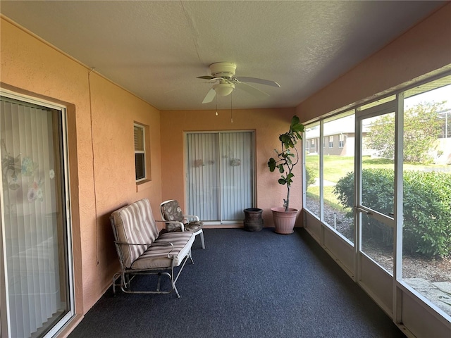 unfurnished sunroom with ceiling fan