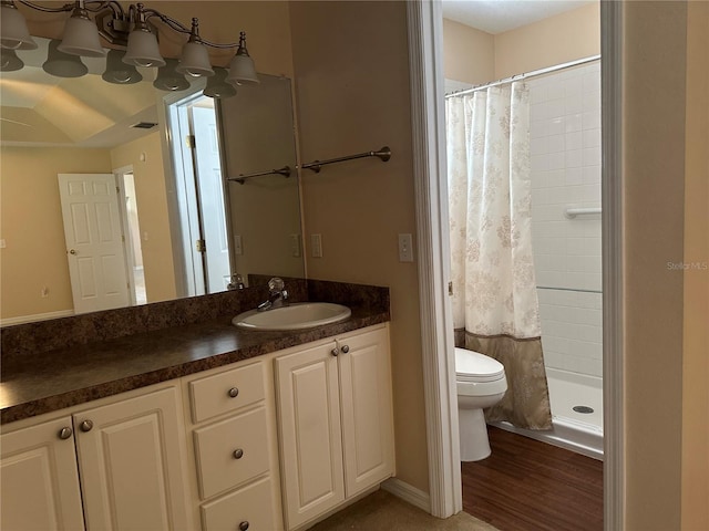 bathroom featuring walk in shower, hardwood / wood-style flooring, vanity, and toilet