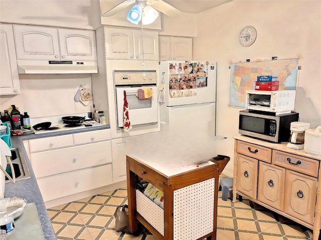 kitchen featuring ceiling fan, white appliances, and white cabinets