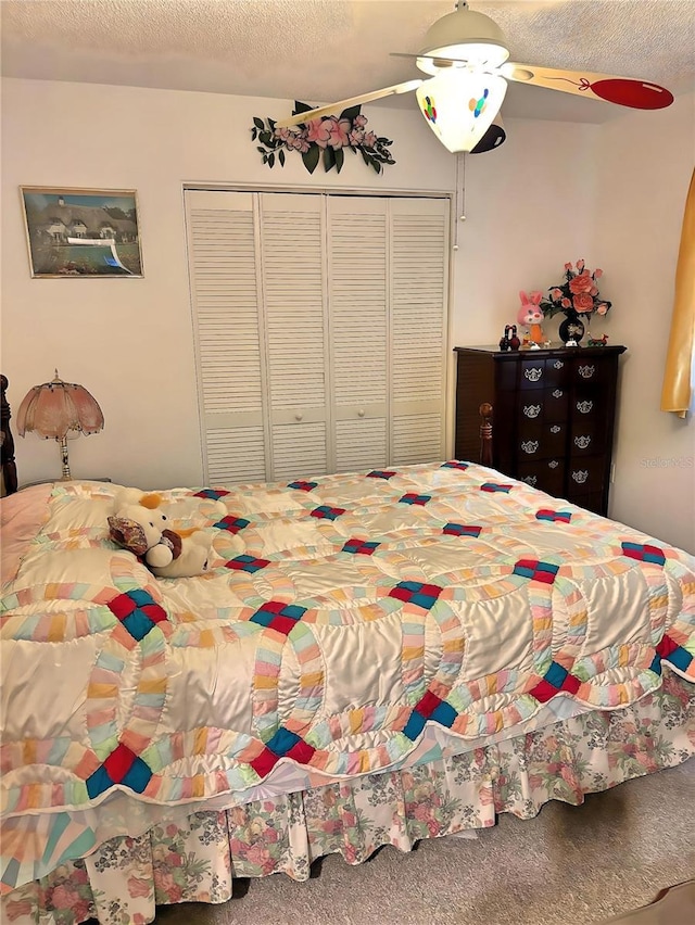 bedroom with ceiling fan, carpet floors, a closet, and a textured ceiling