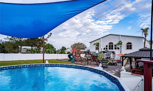 view of swimming pool featuring a playground and a gazebo