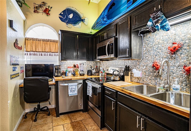 kitchen with backsplash, wood counters, sink, and appliances with stainless steel finishes