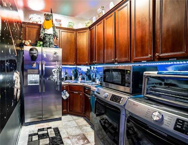 kitchen with washing machine and dryer and appliances with stainless steel finishes